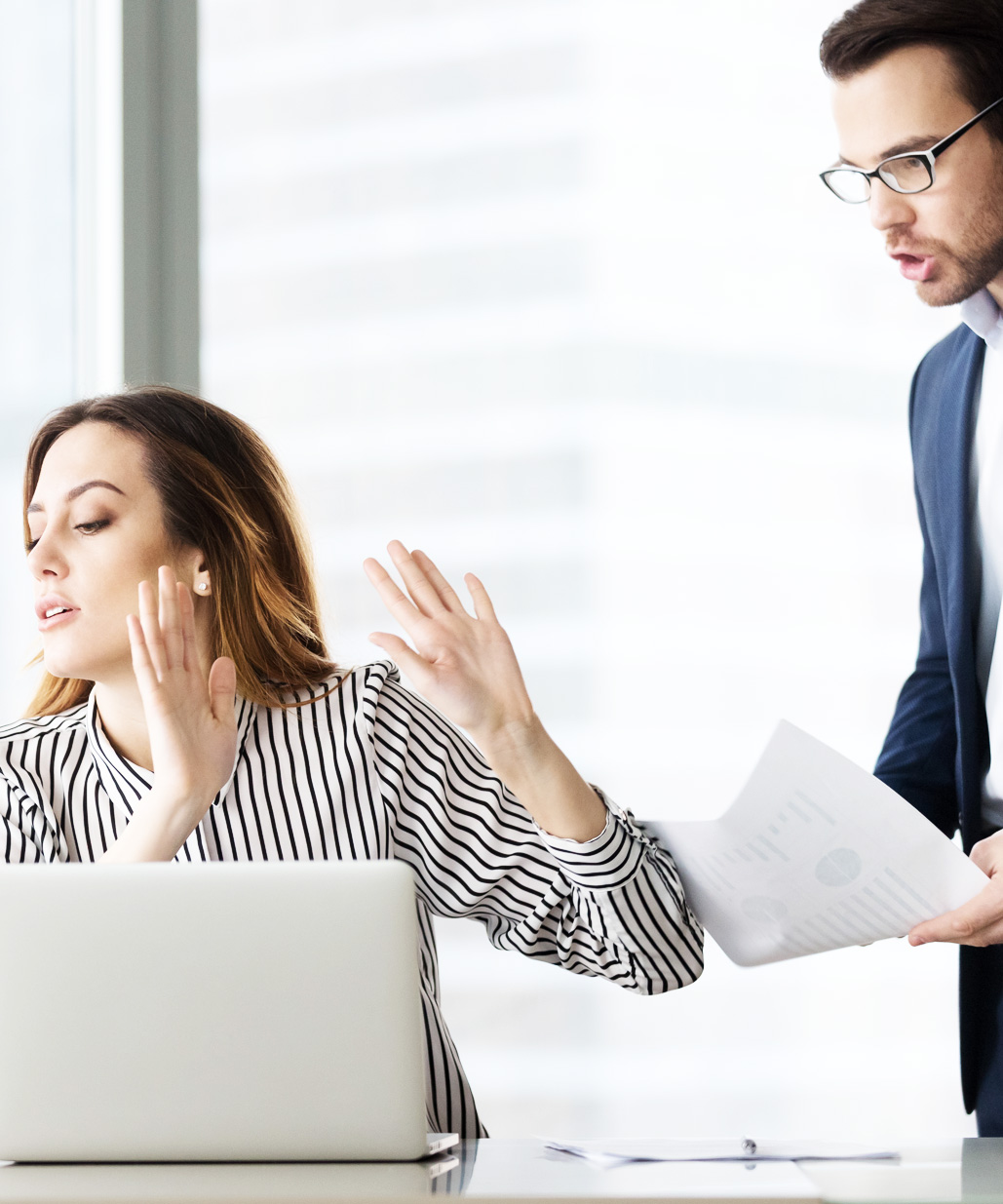 Frau wehrt im Büro eine Diskussion ab, während ein Kollege mit erhobener Stimme spricht – Symbolbild für Spannungen, Kommunikationsprobleme und fehlende Wertschätzung im Arbeitsalltag